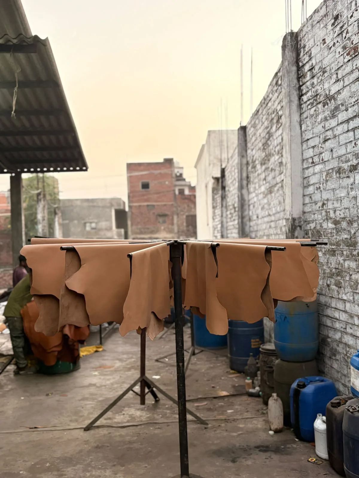 Leather hides hanging to dry on a rotating rack in the open air