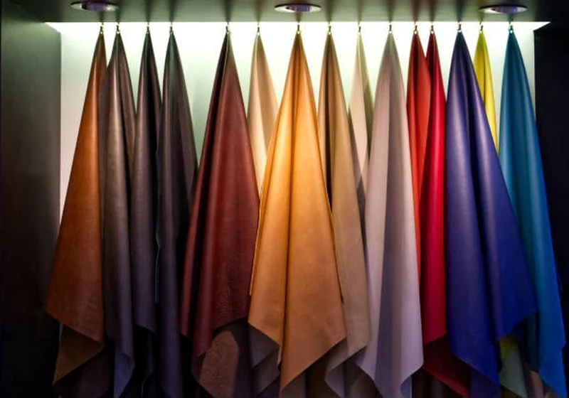 Finished leather hides in tan, brown, red and blue hanging in the tannery