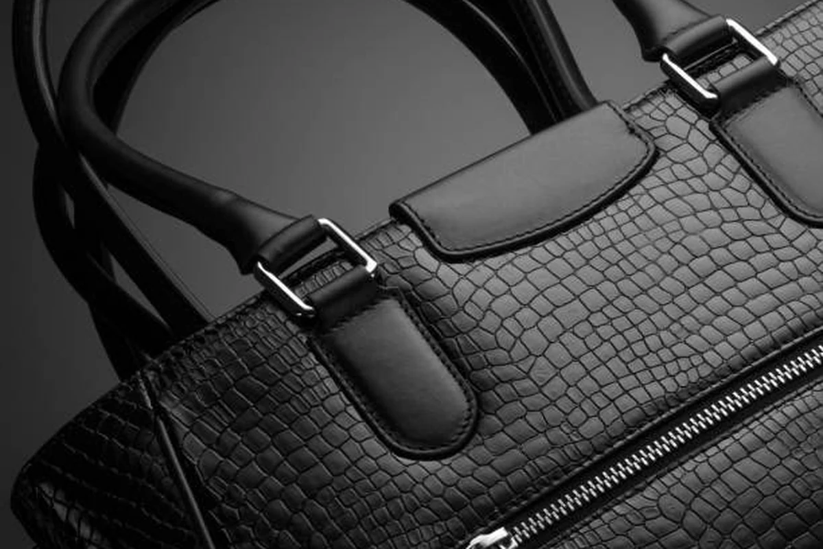 A black woven-leather handbag with polished silver buckles, finished by Alam’s International